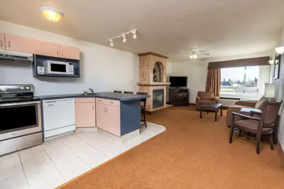 a large kitchen and living room with a table and chairs at Super 8 by Wyndham Vermilion AB in Vermilion