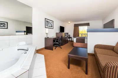 a hotel room with a bathroom and a bed at Super 8 by Wyndham Vermilion AB in Vermilion