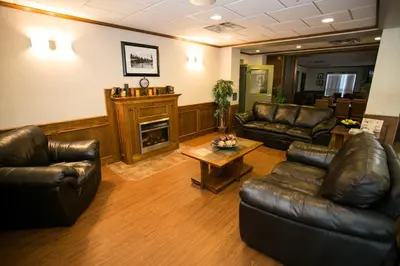 a living room with leather furniture and a fireplace at Service Plus Inns & Suites Drayton Valley in Drayton Valley