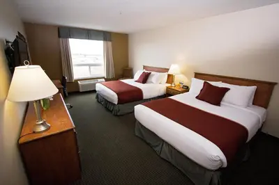 a hotel room with two beds and a window at Service Plus Inns & Suites Drayton Valley in Drayton Valley