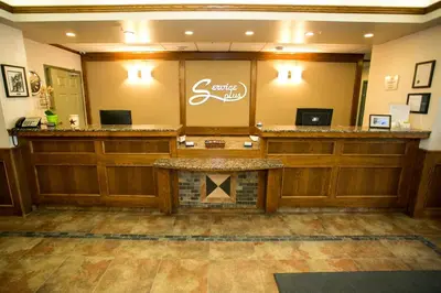 a waiting room with a counter and a fireplace at Service Plus Inns & Suites Drayton Valley in Drayton Valley