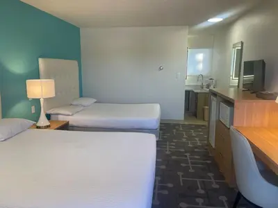 a hotel room with two beds and a television at Howard Johnson by Wyndham Hinton in Hinton
