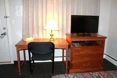 a desk with a television and a chair in a hotel room at Tel Star Motel in Brooks