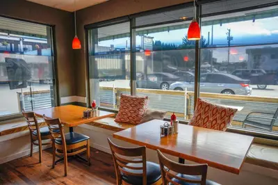 a restaurant with two tables and chairs and a large window at Thunderbird Motor Inn in Duncan