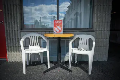 a table with two chairs and a table with a sign at Thunderbird Motor Inn in Duncan