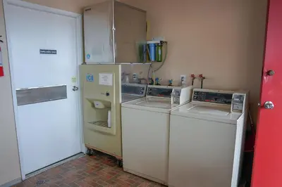 a kitchen with a refrigerator and a washer and dryer at Thunderbird Motor Inn in Duncan
