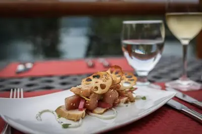 a plate of food on a table with a glass of wine at Tyax Lodge & Heliskiing in Gold Bridge
