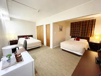 a hotel room with two beds and a desk at Valhalla Inn in New Denver