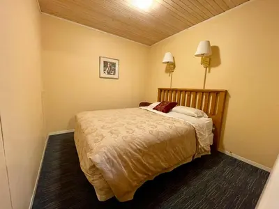 a bedroom with a bed and two lamps on the wall at Valhalla Inn in New Denver