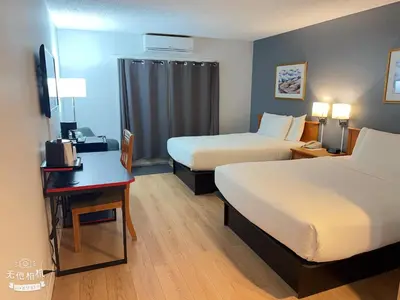 a hotel room with two beds and a desk at Wells Gray Inn in Clearwater