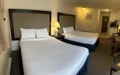 a hotel room with two beds and a table and chairs at Wessex Inn By The Sea in Cowichan Bay