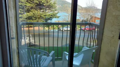 a balcony with two chairs and a view of a street at Wessex Inn By The Sea in Cowichan Bay