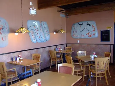 a restaurant with tables and chairs and signs on the wall at The Yukon Inn in Whitehorse