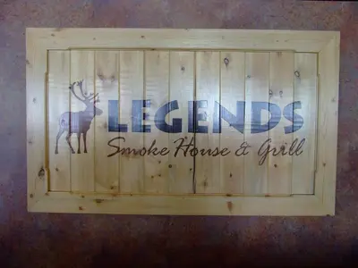 a wooden sign with a deer on a wall at The Yukon Inn in Whitehorse