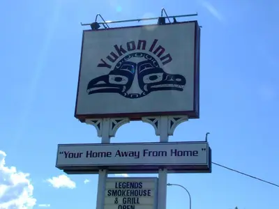 a sign for a malcolm inn on a street at The Yukon Inn in Whitehorse