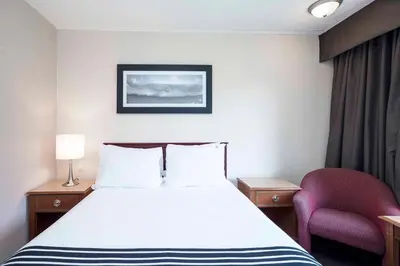 a hotel room with a bed and a chair at Sandman Inn McBride in McBride