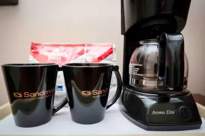 two coffee cups sitting on a counter next to a coffee maker at Sandman Inn Princeton in Princeton