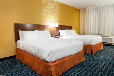 two beds in a hotel room with yellow walls at Fairfield Inn & Suites by Marriott Vernon in Vernon