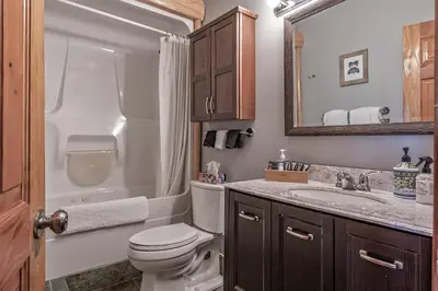 a bathroom with a toilet and a sink and a mirror at Spirit Lodge at Silverstar in Vernon