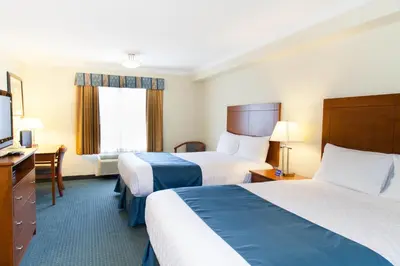 a hotel room with two beds and a flat screen tv at Hinton Lodge in Hinton