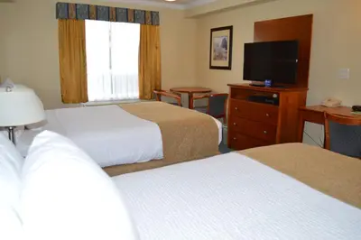 a hotel room with two beds and a flat screen tv at Hinton Lodge in Hinton
