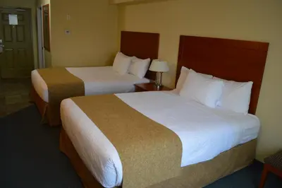 a hotel room with two beds and a lamp at Hinton Lodge in Hinton