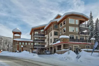 a large apartment building with snow on the ground at Kookaburra Lodge #202 By Bear Country in Sun Peaks