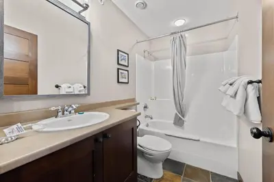 a bathroom with a sink and a toilet and a shower at Stones Throw #26 By Bear Country in Sun Peaks