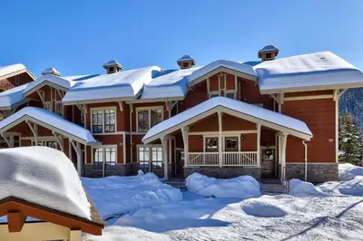 a large house covered in snow at Stones Throw #26 By Bear Country in Sun Peaks