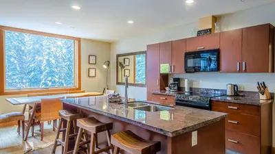 a kitchen with a counter and a large window at Kookaburra Lodge #303 By Bear Country in Sun Peaks