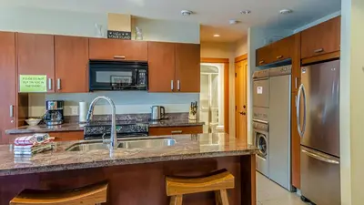 a kitchen with a sink and a refrigerator at Kookaburra Lodge #303 By Bear Country in Sun Peaks
