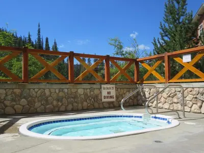 a hot tub with a fence and a no swimming sign at Fireside Lodge #419 By Bear Country in Sun Peaks