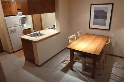 a kitchen with a wooden table and a kitchen with a sink at Holiday Home in Sun Peaks