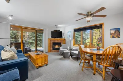 a living room with a blue couch and a table at Snow Creek Village #37 By Bear Country in Sun Peaks