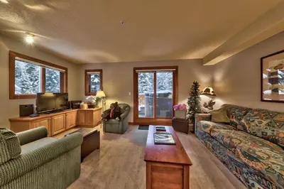 a living room with a couch and a tv at Timberline Village #14 By Bear Country in Sun Peaks