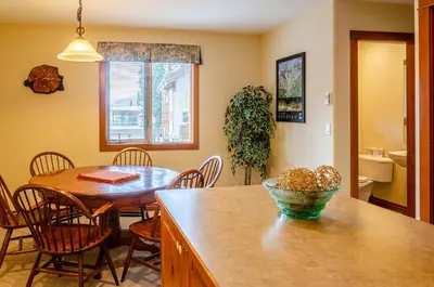 a kitchen and dining room with a table and chairs at Timberline Village #38 By Bear Country in Sun Peaks