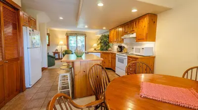 a kitchen with wooden cabinets and a wooden table with a wooden tableablish at Timberline Village #38 By Bear Country in Sun Peaks