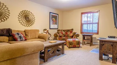 a living room with couches and a table at Woodhaven #32 By Bear Country in Sun Peaks