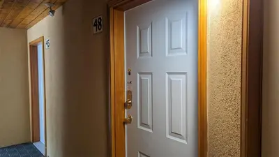 an open white door in a room with a hallway at Snow Creek Village #48 By Bear Country in Sun Peaks