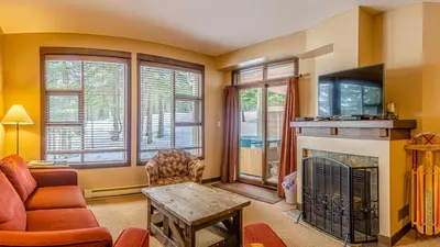 a living room with a couch and a fireplace at Stones Throw #11 By Bear Country in Sun Peaks