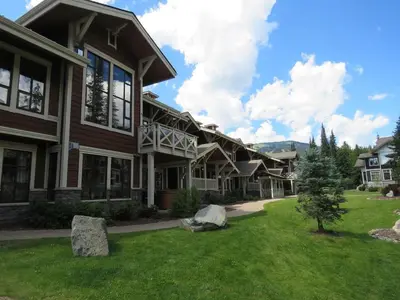 a large house with a lawn in front of it at Stones Throw #11 By Bear Country in Sun Peaks