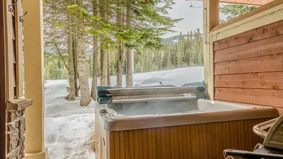 a bath tub sitting inside of a house in the snow at Stones Throw #11 By Bear Country in Sun Peaks