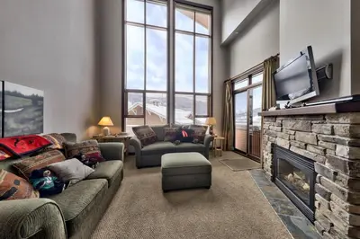 a living room with a couch and a fireplace at Stones Throw #56 By Bear Country in Sun Peaks