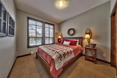a bedroom with a large bed and a window at Stones Throw #56 By Bear Country in Sun Peaks