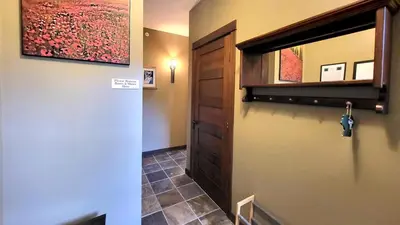 a hallway with a door and a tile floor at Stones Throw #38 By Bear Country in Sun Peaks