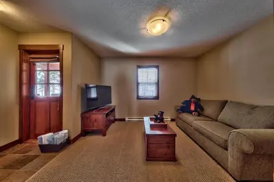a living room with a couch and a television at Trappers Landing #27 By Bear Country in Sun Peaks