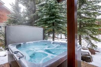 a jacuzzi tub sitting on a porch in the snow at Trappers Landing #11 By Bear Country in Sun Peaks