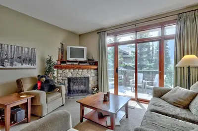 a living room with a teddy bear sitting on a fireplace at Trappers Landing #06 By Bear Country in Sun Peaks