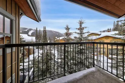 a balcony with a view of a snow covered mountain at Trappers Landing #05 By Bear Country in Sun Peaks