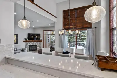 a living room with a fireplace and a dining room at Trappers Landing #05 By Bear Country in Sun Peaks